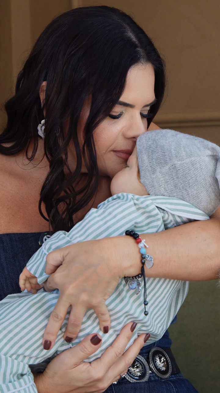 Criadora da Alma Serena Atelier segurando e beijando um bebê reborn